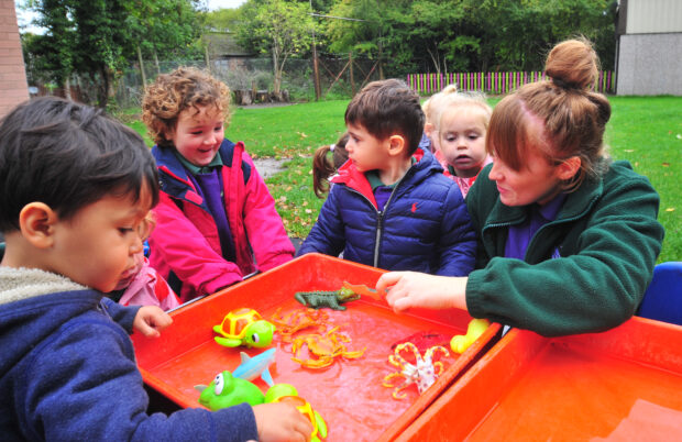 Young children and an adult playing outside